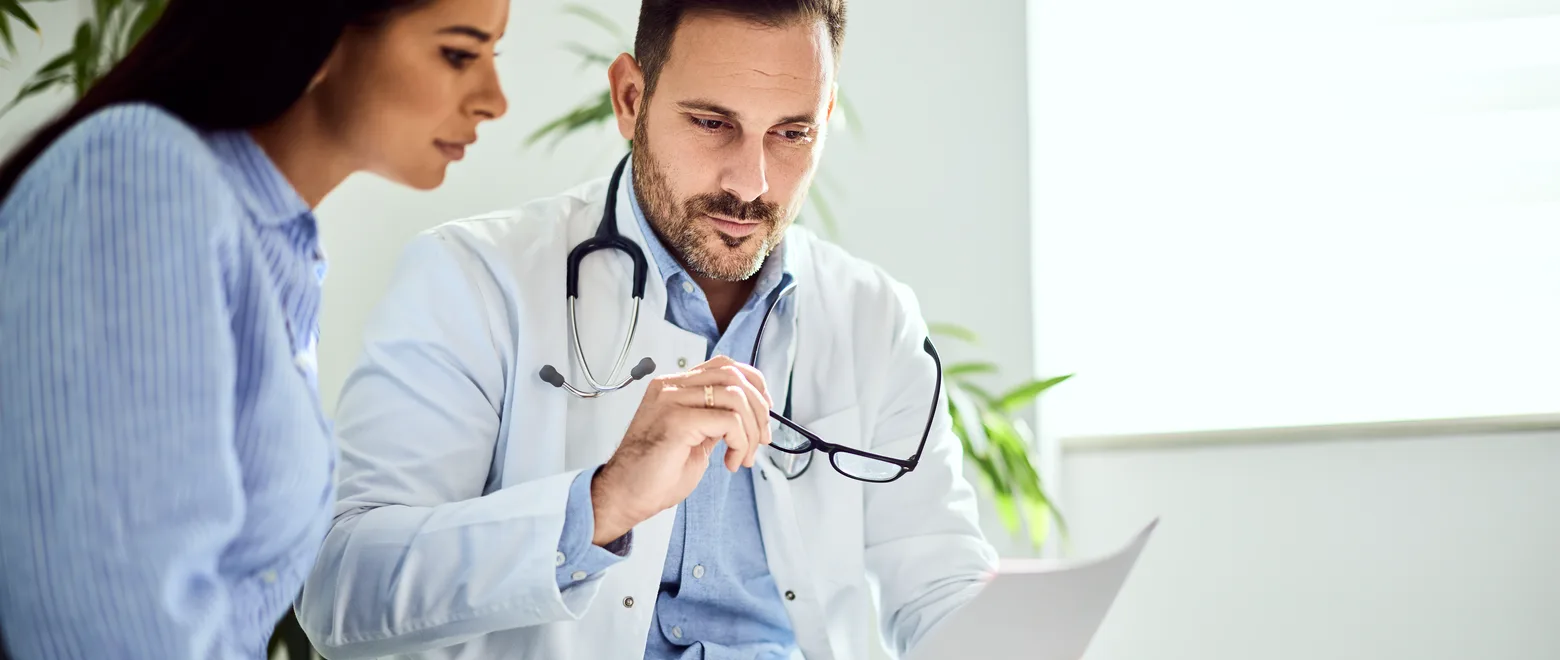 A patient and a clinician reviewing information together in a consulting room